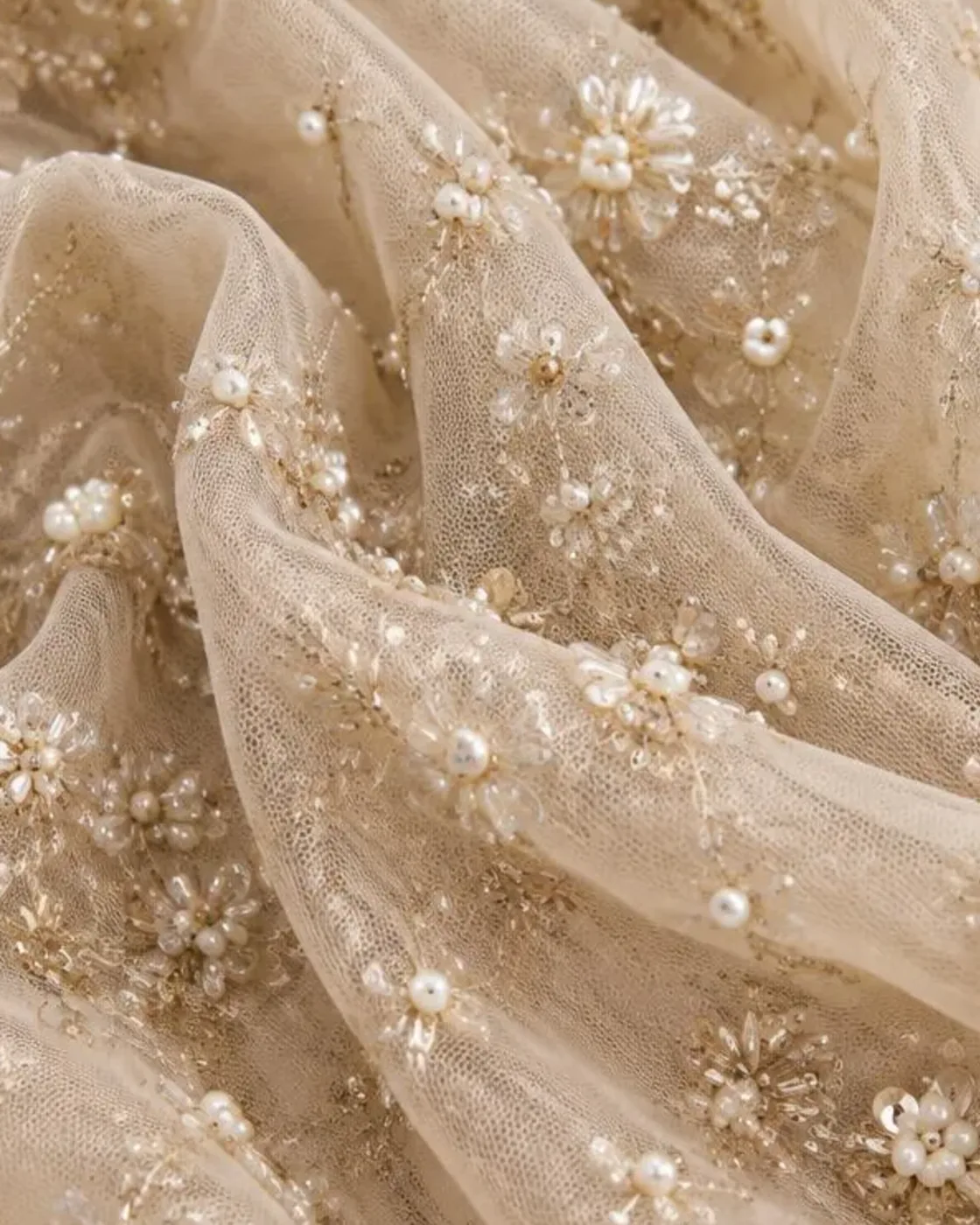 Close-up of cut-dana, pearl and sequin florals on champagne net