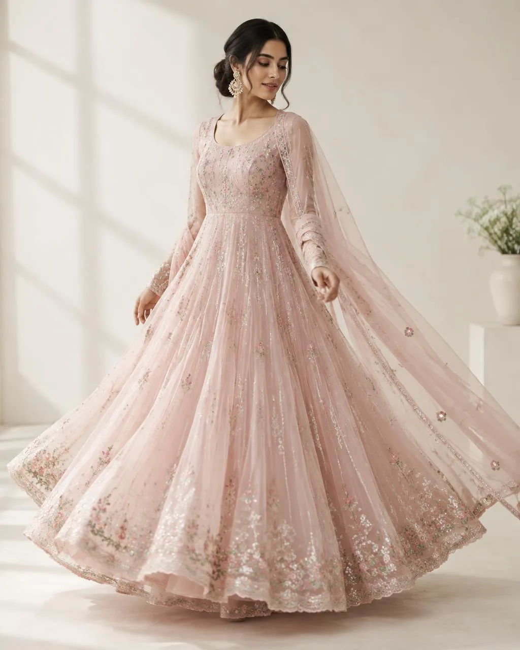 Model twirling in a blush organza anarkali with pastel embroidery